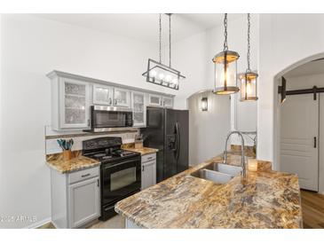 Modern kitchen featuring granite counters, stainless steel appliances, updated cabinets, and stylish pendant lighting at 974 E Palomino Way, San Tan Valley, AZ 85143