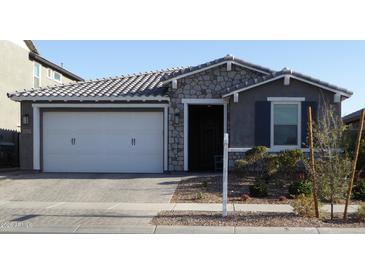 Charming single-Gathering home featuring a stone facade, a two-car garage, and well-maintained landscaping at 9821 E Supernova Dr, Mesa, AZ 85212