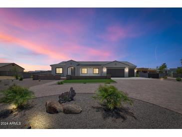 Stunning single-story home featuring a brick driveway, desert landscaping, and a three-car garage at 10147 W Camino De Oro --, Peoria, AZ 85383