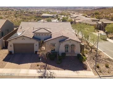 Charming single-story home features desert landscaping, a tile roof, and a two-car garage at 10249 W Redbird Rd, Peoria, AZ 85383