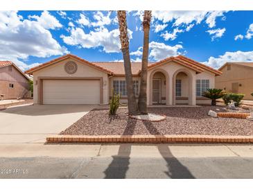 Charming home with a well-maintained desert landscape, palm trees, and a two-car garage at 1549 E Westchester Dr, Chandler, AZ 85249