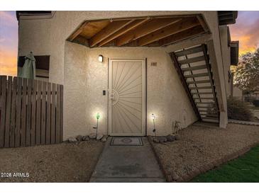 Inviting front door with unique design, complemented by warm lighting and well-maintained landscaping at 16402 N 31St St # 107, Phoenix, AZ 85032