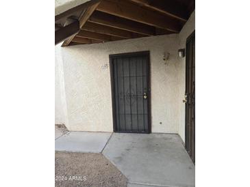 Exterior view of the unit's secure front door with a covered walkway, and easy access to parking at 16402 N 31St St # 117, Phoenix, AZ 85032