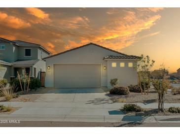 Charming single-story home with neutral stucco, two car garage and easy to maintain desert landscaping at 17487 W Daley Ln, Surprise, AZ 85387