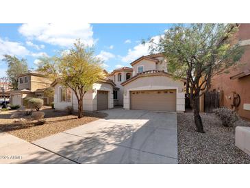 Charming two-story home featuring a three-car garage and well-maintained landscaping in a residential neighborhood at 17655 W Tasha Dr, Surprise, AZ 85388