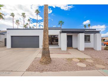 Contemporary home featuring a white exterior, gray accents, desert landscaping and attached garage at 1847 W Isleta Ave, Mesa, AZ 85202