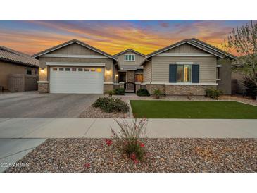 Charming single-story home featuring a two-car garage, manicured lawn, and inviting front entrance at 20102 E Robin Rd, Queen Creek, AZ 85142