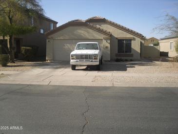 Charming single-level home with a well-manicured front yard and a two-car garage at 2156 W Broadway Ave, Coolidge, AZ 85128