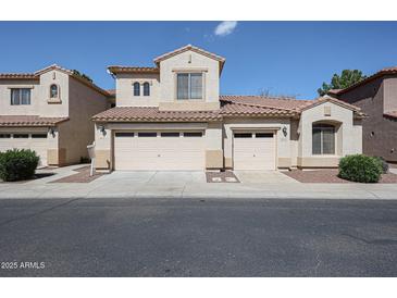 Beige, two story home with two garages, tile roof and desert landscaping at 2600 E Springfield Pl # 59, Chandler, AZ 85286