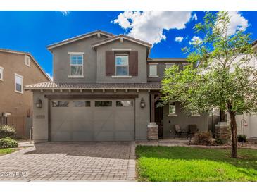 Charming two-story home featuring a two car garage, desert landscaping, and covered front porch with furniture at 4281 E Mesquite St, Gilbert, AZ 85296