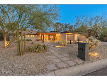 Charming single-story home featuring a well-maintained xeriscaped front yard and two-car garage at 5507 N Calle Del Santo --, Phoenix, AZ 85018