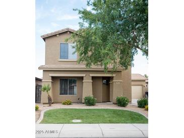 Two-story home with a well-maintained lawn, mature landscaping, and neutral-toned stucco exterior at 559 E Rainbow Dr, Chandler, AZ 85249