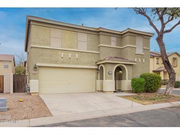 Two-story home with tan stucco, two car garage, covered front porch, and partial bare tree in the front yard at 8527 E Lindner Ave, Mesa, AZ 85209