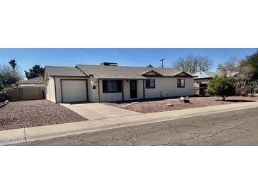 Charming single-story home featuring a well-maintained front yard with mature landscaping and a driveway at 1001 W 17Th St, Tempe, AZ 85281