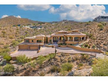 Expansive hillside home featuring a desert landscape, stone accents and clay tile roofing at 14360 E Desert Cove Ave, Scottsdale, AZ 85259