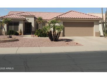 Charming single-story home featuring a well-maintained landscape and a two-car garage at 15104 W Pinehurst W Ln, Surprise, AZ 85374