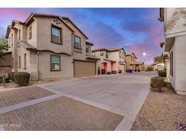 View of several homes with front garages in community with colorful sunset in background at 291 N Scott Dr, Chandler, AZ 85225