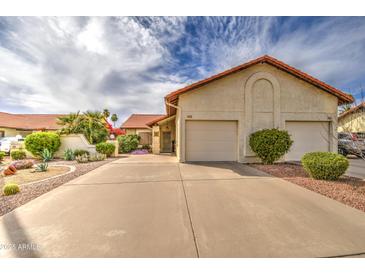 Charming single-story home featuring a two-car garage, manicured landscaping, and a tiled roof at 542 S Higley Rd # 102, Mesa, AZ 85206