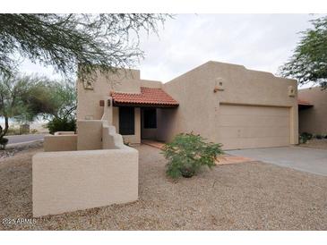 Charming desert home with a red tile roof and a xeriscaped yard and covered entry at 10812 N 117Th Pl, Scottsdale, AZ 85259