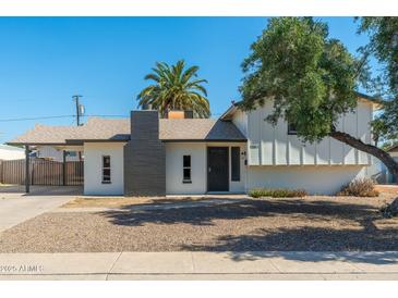 Charming single-Gathering home featuring a gray painted chimney and a covered front porch at 13807 N 33Rd Dr, Phoenix, AZ 85053