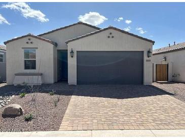 Charming single-story home with a paved driveway and two-car garage at 18105 W Hiddenview Dr, Goodyear, AZ 85338