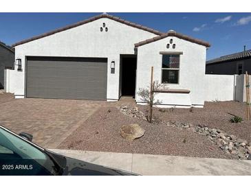 A charming single-story home featuring a neutral color palette, complemented by a two-car garage and a low maintenance front yard at 18126 W Hiddenview Dr, Goodyear, AZ 85395