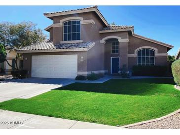 Inviting two-story home featuring a well-manicured lawn, tile roof, and attached two car garage at 2542 S Rowen St, Mesa, AZ 85209