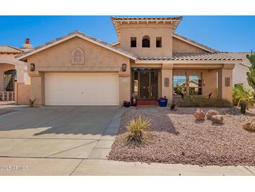 Charming home featuring desert landscaping, tile roof, and an attached two-car garage at 6531 E Star Valley St, Mesa, AZ 85215