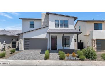 Stunning two-story home featuring a gray garage door, modern design, and desert landscaping at 6735 N 9Th Dr, Phoenix, AZ 85013