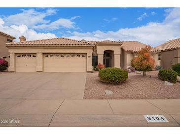 Charming single-story home with a tile roof, desert landscaping, and a spacious three-car garage at 9104 E Hillery Dr, Scottsdale, AZ 85260