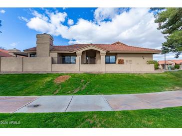 Charming home featuring stucco siding, a red tile roof, and lush green grass and landscaping at 945 N Pasadena St # 61, Mesa, AZ 85201