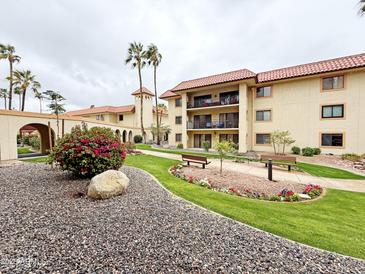 Beautiful condo complex with desert landscaping and palm trees on an overcast day at 10330 W Thunderbird Blvd # B101, Sun City, AZ 85351