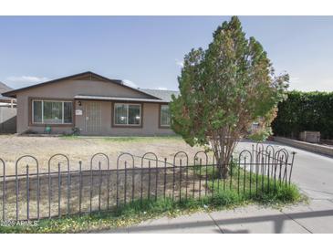 Charming single-story home featuring a well-maintained front yard and mature tree, enhancing its curb appeal at 2201 W Wethersfield Rd, Phoenix, AZ 85029