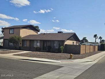 Tan two-story home with a gravel yard and desert landscaping plus a tall brick fence along the perimeter at 2255 W Bloomfield Rd, Phoenix, AZ 85029