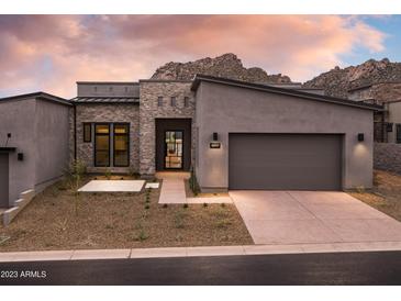 Stunning modern home featuring a two-car garage, beautiful stone accents, and desert landscaping at 23880 N 127Th St, Scottsdale, AZ 85255