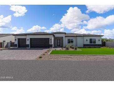 Beautiful single-story home with a modern design, three-car garage, and well-manicured lawn at 33402 N 142Nd Way, Scottsdale, AZ 85262