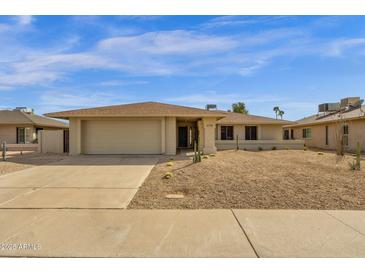 Charming single-story home with a two-car garage and a desert-landscaped front yard at 6759 E Aire Libre Ln, Scottsdale, AZ 85254