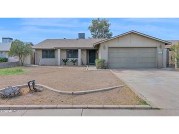 Single-story home featuring a two-car garage and a desert landscape at 6824 N 31 Ave, Phoenix, AZ 85017