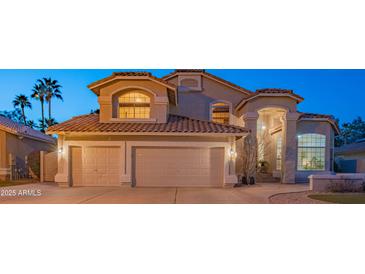 Charming home featuring a three-car garage, well-manicured lawn, and a beautiful tile roof at 7826 W Kerry Ln, Glendale, AZ 85308