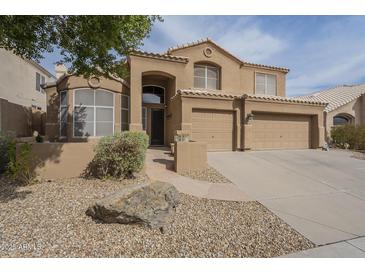 Charming two-story home featuring desert landscaping, a tile roof, and an attached three-car garage at 908 E Mountain Sage Dr, Phoenix, AZ 85048