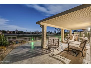 Spacious covered patio features elegant seating, stone columns, and scenic golf course views at 9409 W Taro Ln, Peoria, AZ 85382