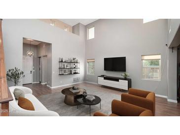 Bright living room boasts soaring ceilings, modern shelving, and stylish contemporary furnishings at 13346 W Jesse Red Dr, Peoria, AZ 85383