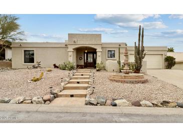 Southwest-style home featuring desert landscaping, a stone fountain, and a covered front porch at 15440 E Mustang Dr, Fountain Hills, AZ 85268