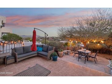 Outdoor patio featuring cozy seating, a table, and a vibrant umbrella, ideal for relaxing and enjoying mountain views at 15510 E Sycamore Dr, Fountain Hills, AZ 85268