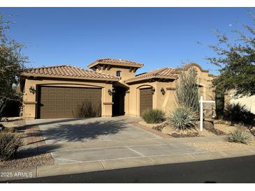 Charming single-story home featuring a tile roof, a three-car garage, and desert landscaping at 1708 W Dusty Wren Dr, Phoenix, AZ 85085