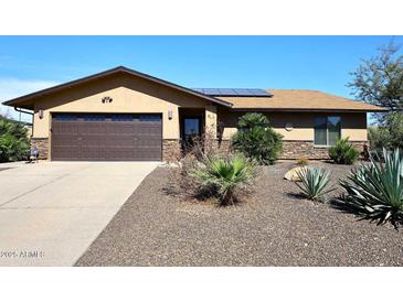 Single-story home featuring a two-car garage, desert landscaping, and stone veneer accents on the facade at 1920 E Manzanita Dr, Phoenix, AZ 85020