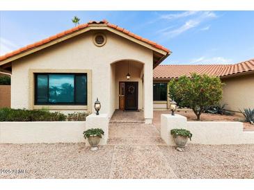 Welcoming home exterior with an arched entrance, custom door, and desert landscaping at 2923 N 63Rd St, Mesa, AZ 85215