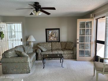 Inviting living room with comfortable seating, a ceiling fan, and access to the outdoors, perfect for relaxation at 5518 E Lindstrom Ln # 3010, Mesa, AZ 85215