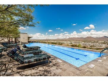 Modern pool with lounge seating, stunning mountain views, and clear blue skies at 7180 E Kierland Blvd # 312, Scottsdale, AZ 85254