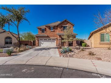 Two-story stucco home showcasing a tile roof, landscaped front yard, and a wide driveway leading to a two-car garage at 7252 N 90Th Ln, Glendale, AZ 85305